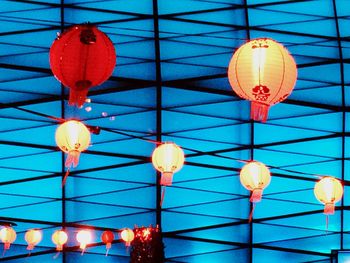 Low angle view of illuminated lamp hanging on ceiling