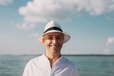 Portrait of smiling man in sea against sky