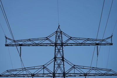 Low angle view of electricity pylon against sky