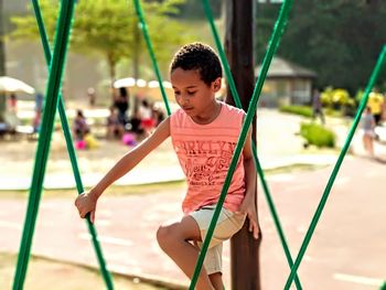 Boy on play equipment at park