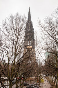 Low angle view of trees and building against sky