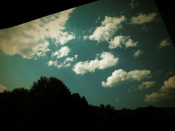 Low angle view of silhouette trees against sky