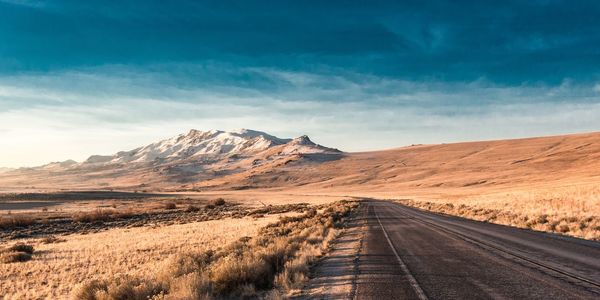 Road amidst desert against sky