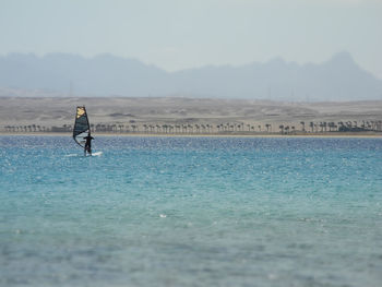 Man in sea against sky