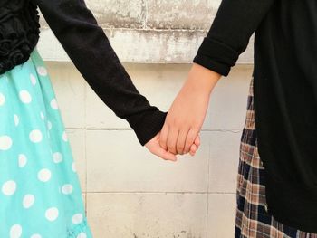 Midsection of couple holding hands