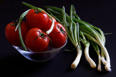 Close-up of tomatoes on table against black background