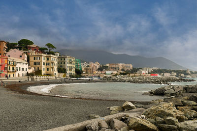 Buildings by sea against sky