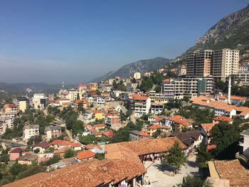 High angle view of cityscape by sea against clear sky