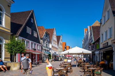 People walking on street amidst buildings in city