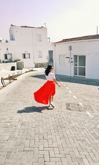 Rear view of woman walking on footpath in city