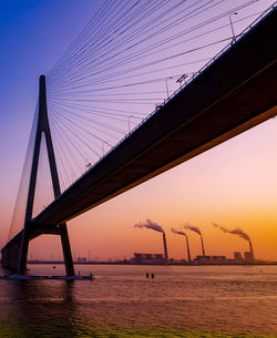 Low angle view of suspension bridge against sky during sunset