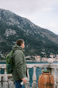 Rear view of man standing against mountain