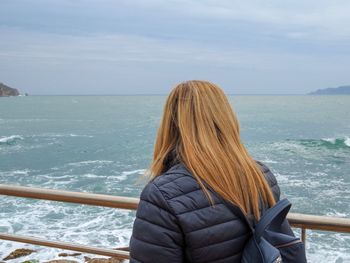 Rear view of woman looking at sea against sky