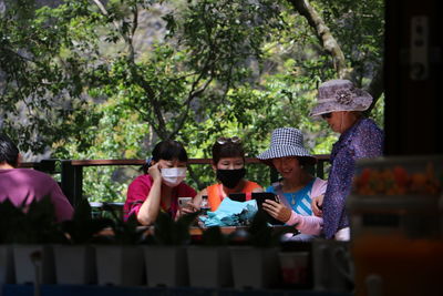 Rear view of people sitting in park