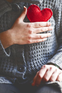 Midsection of woman wearing sweater with heart shape