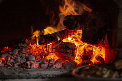 Burning log of wood in a fireplace close-up.