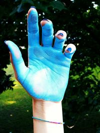 Close-up of human hand against blue background