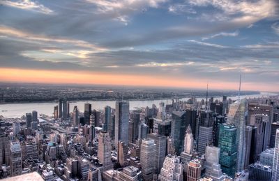 Aerial view of buildings in city against sky during sunset