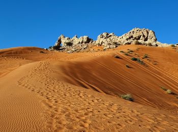 Scenic view of desert against clear blue sky