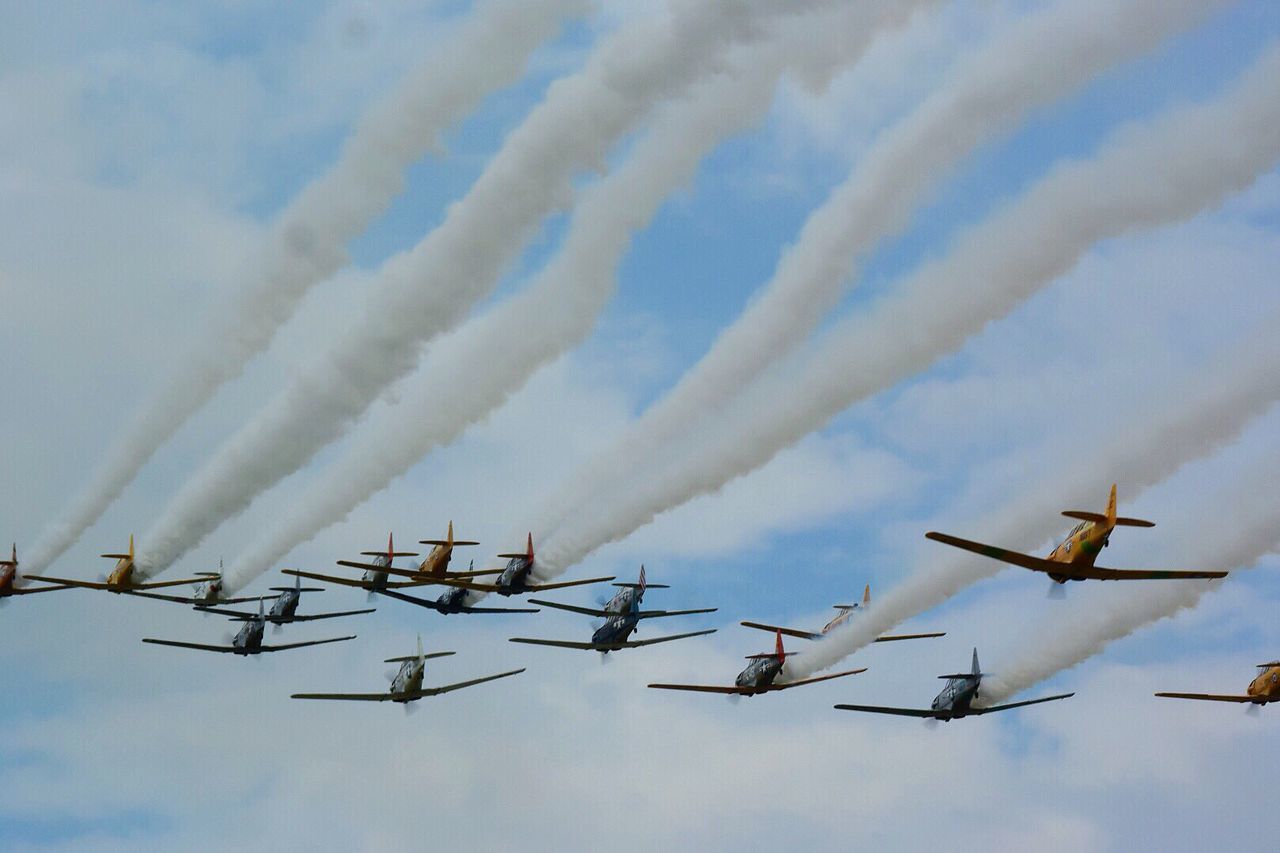 airplane, sky, air vehicle, airshow, cloud - sky, smoke - physical structure, fighter plane, in a row, flying, teamwork, low angle view, transportation, military airplane, no people, mode of transport, arrangement, outdoors, day, vapor trail, multi colored, nature