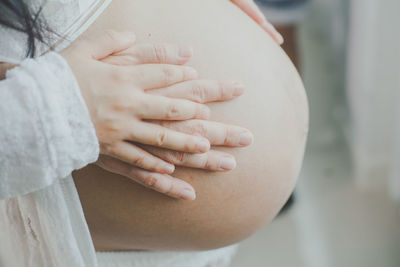 Midsection of woman touching mirror