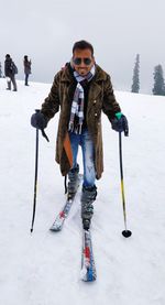 Full length portrait of man skiing on snow field during winter