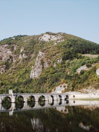 Bridge over mountains against clear sky