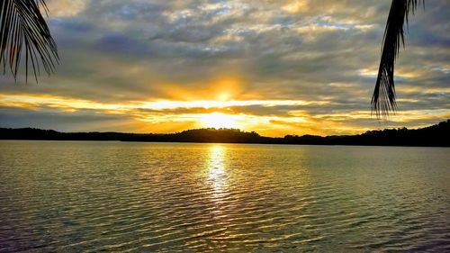 Scenic view of sea against dramatic sky during sunset