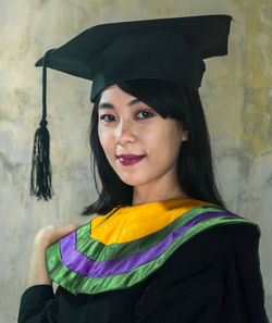 Portrait of smiling woman standing against multi colored background