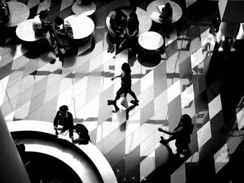 High angle view of people walking on tiled floor
