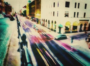 Blurred motion of people on city street and buildings