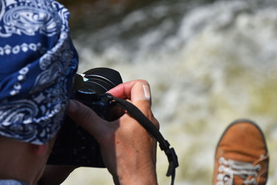 Close-up of photographer photographing waterfall