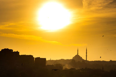 Silhouette of buildings against sky during sunset