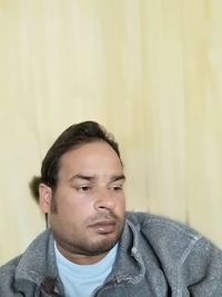 Portrait of young man against wall