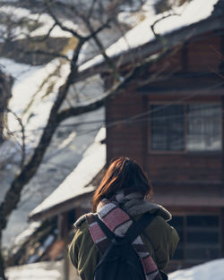 Rear view of woman standing in snow