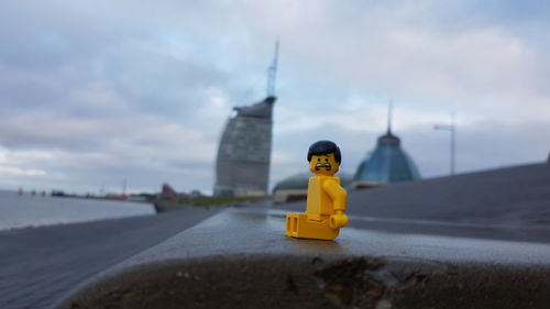 Yellow toy car on land against sky