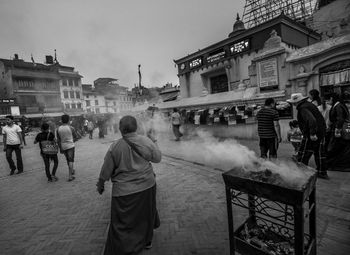 Rear view of people walking on street in city