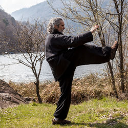 Man standing at lakeshore during winter