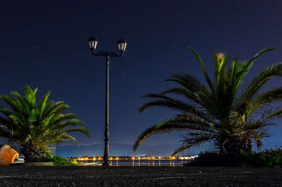 Low angle view of illuminated street light against blue sky