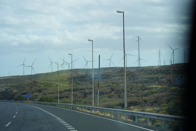 Road by field against sky