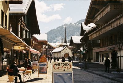 People on street amidst buildings in city