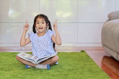 Portrait of cute girl sitting on grass