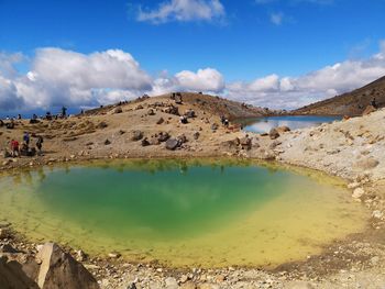 Scenic view of volcanic lake against cloudy sky