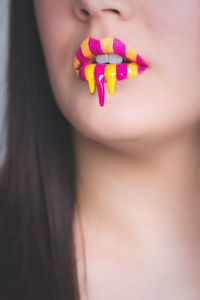 Cropped image of woman with yellow and pink matte liquid lipstick