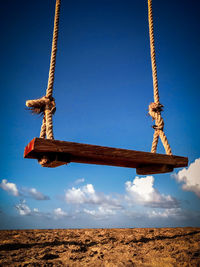 Low angle view of swing against sky