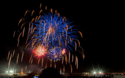 Low angle view of firework display at night  multiple bursts of colorful drama