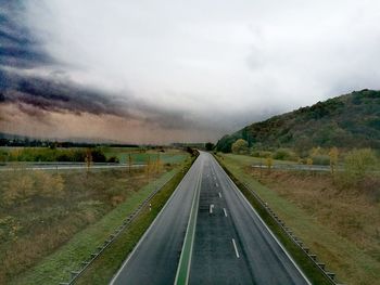 Empty road along countryside landscape