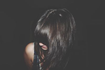 Close-up of smiling mid adult woman against black background