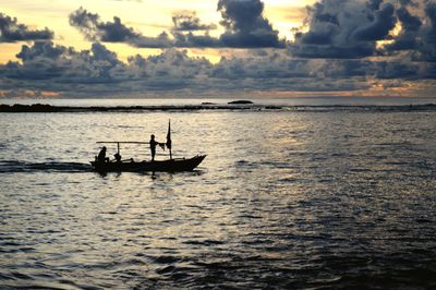 Silhouette boat in sea against sky during sunset
