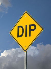 Low angle view of road sign against cloudy sky